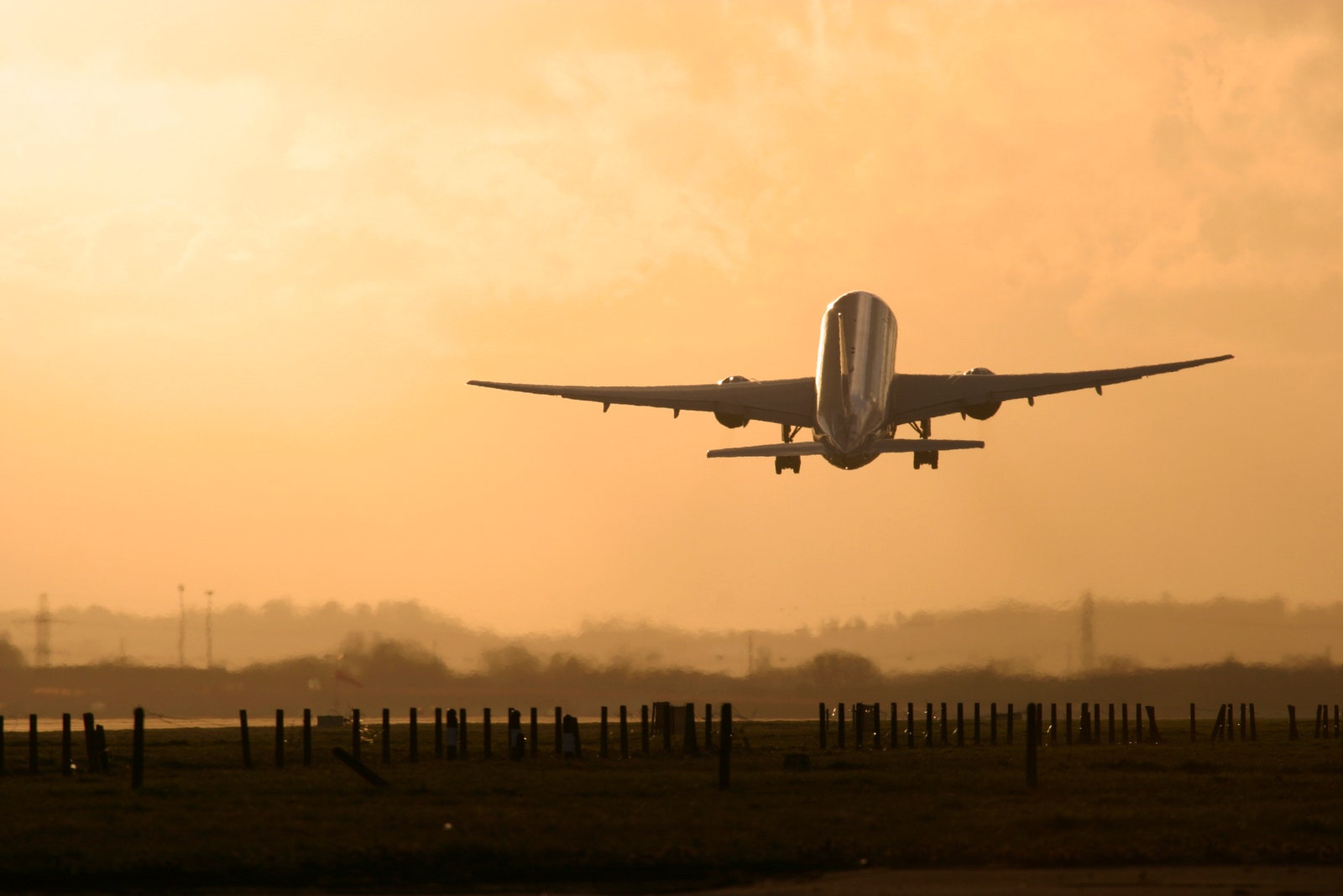 Commercial aircraft taking off in the sunset